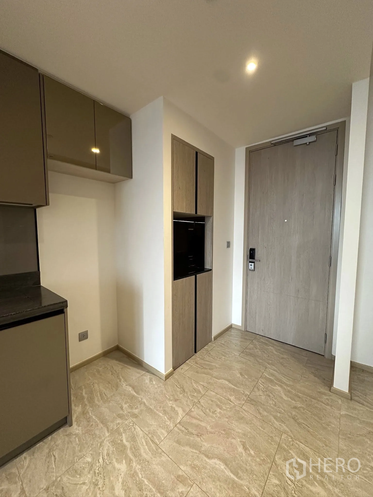 Condominium for sale in Din Daeng, Bangkok - Entry and compact kitchen with glossy cabinets, built-in microwave or oven, and stone tile flooring.