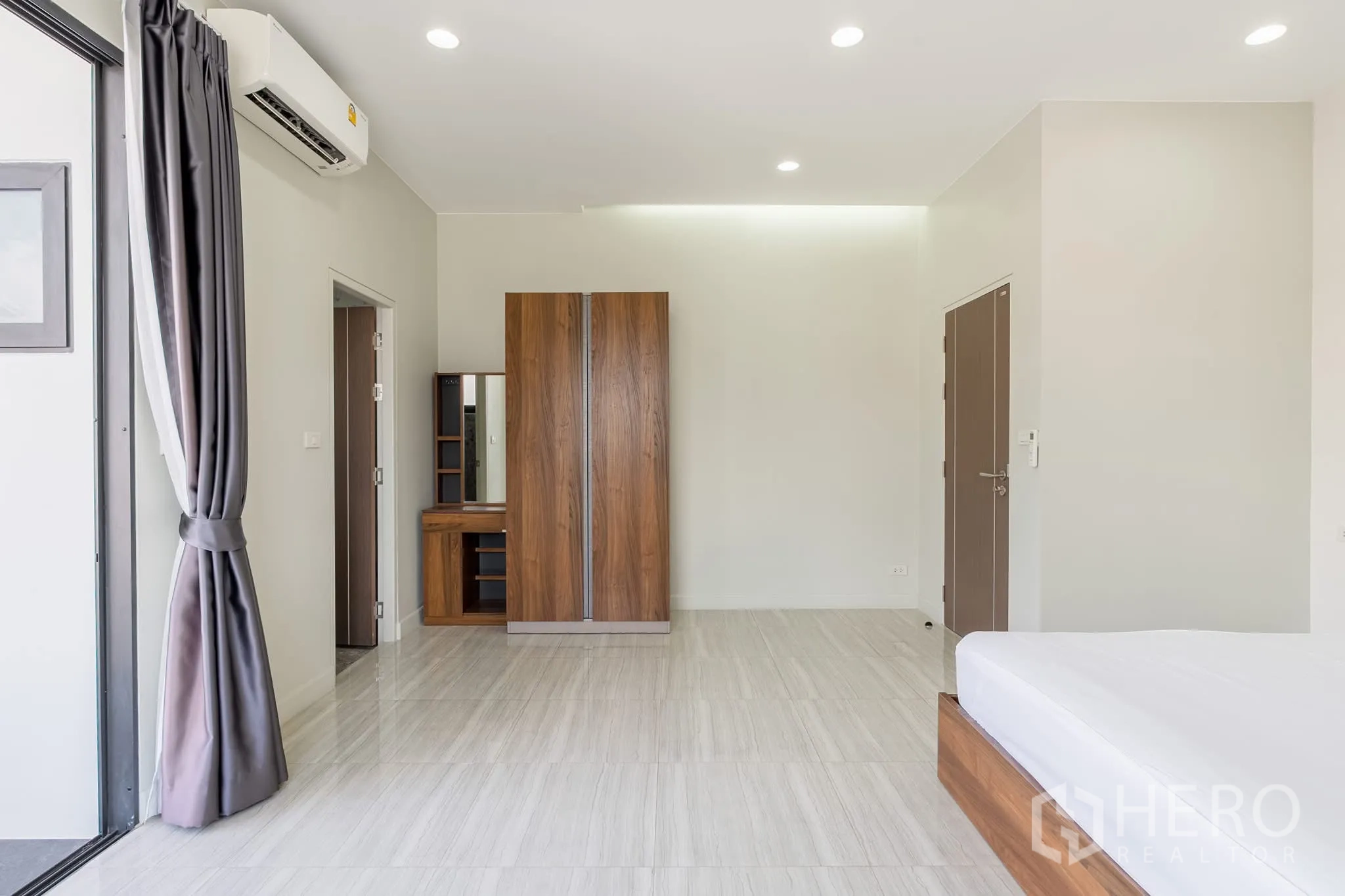 Home Office for rent in Khlong Toei, Bangkok - Bedroom area with wardrobe and dressing table in warm wood finish.