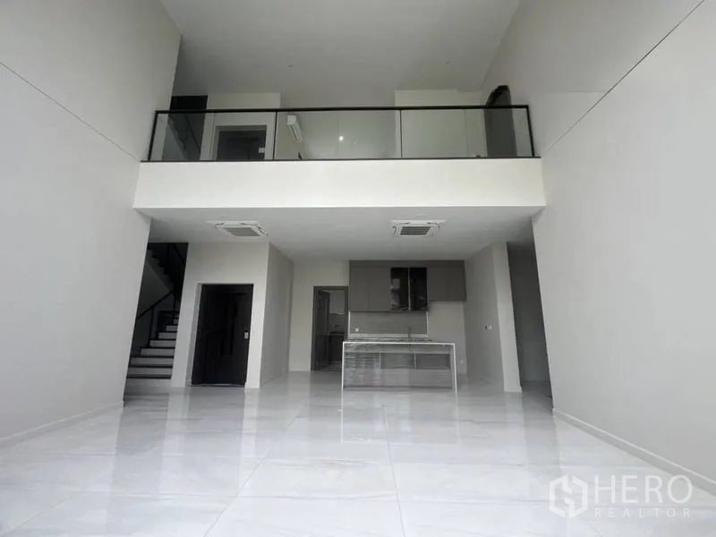 Detached House for rent - Double-height living area with mezzanine, open kitchen and glossy tiled floors.