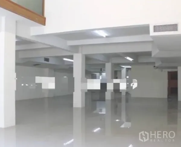 Shophouse for rent in Khlong Toei, Bangkok - Expansive upper level workspace with white pillars, glossy floors, and ceiling strip lighting.