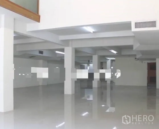 Shophouse for rent in Khlong Toei, Bangkok - Expansive upper level workspace with white pillars, glossy floors, and ceiling strip lighting.