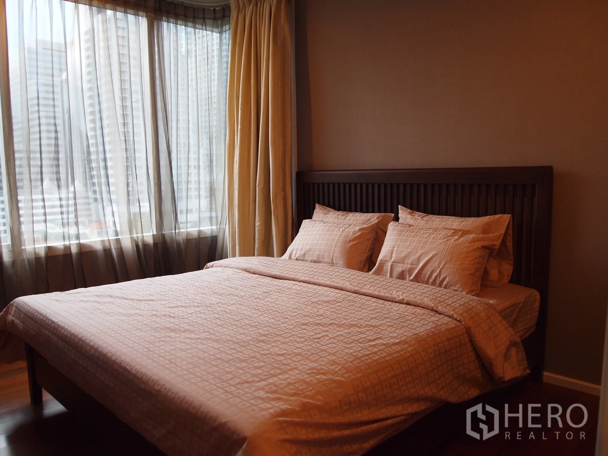 Condominium for rent or sale in Watthana, Bangkok - Master bedroom with large window, sheer curtains and city skyline view.