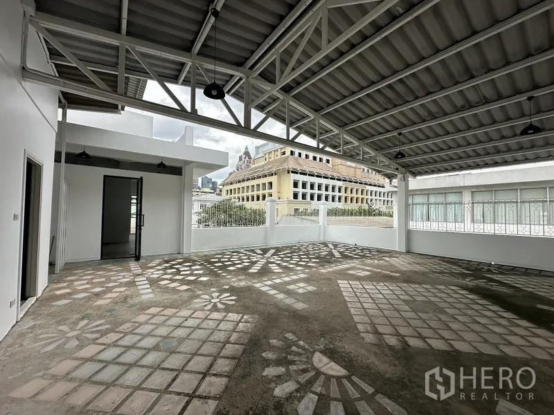 Retail Space for rent in Bang Rak, Bangkok - Large covered terrace with steel trusses and patterned concrete floor overlooking the city.