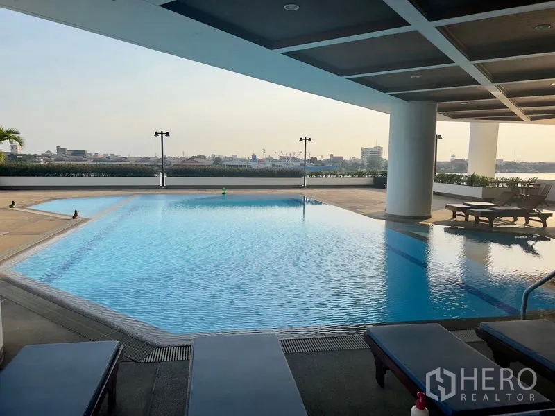 คอนโด ให้เช่าในBang Kho Laem, Bangkok - สระว่ายน้ำขนาดใหญ่มีหลังคา พร้อมเตียงอาบแดดและวิวเมืองกับแม่น้ำของคอนโด