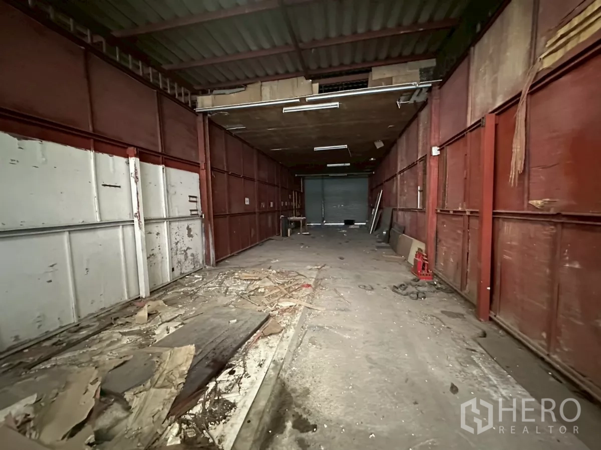 Warehouse for rent or sale in Yan Nawa, Bangkok - Enclosed loading corridor with metal panels and a shutter door for goods staging.