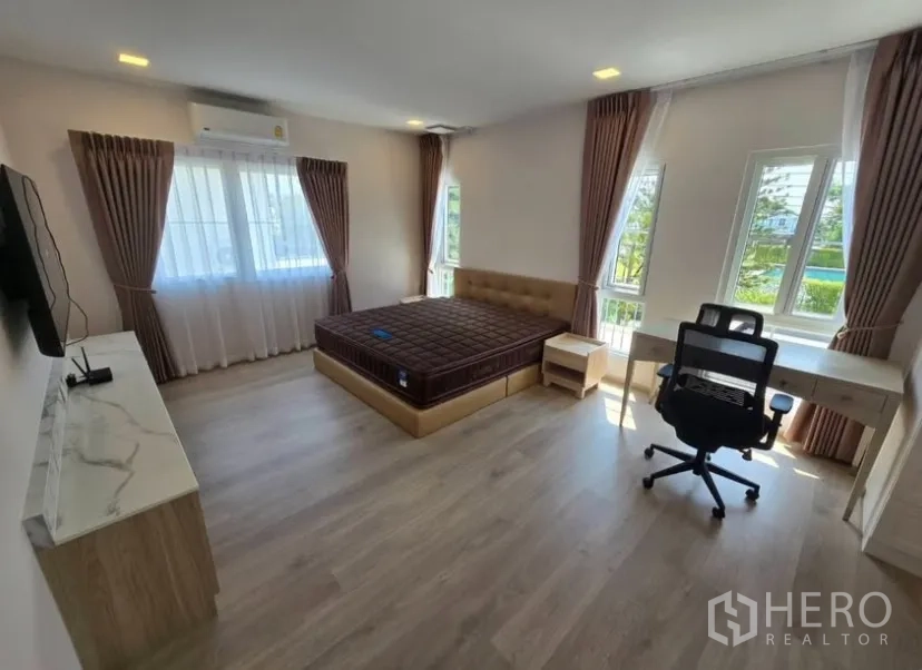 独立式住宅 for rent in Bang Phli, Samut Prakan - 主卧转角视角，呈现床、书桌与充足自然光。