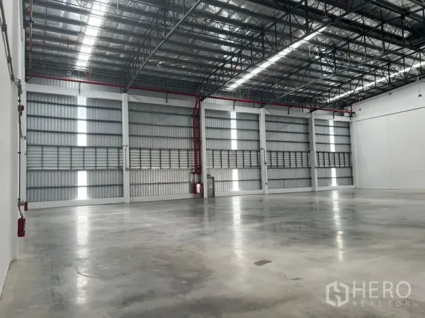 工厂 出租在Bang Pakong, Chachoengsao - 仓库侧墙配通风板与红色消防喷淋管道，墙体高大。