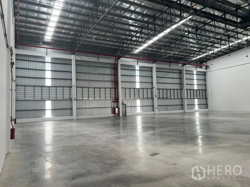 工厂 出租在Bang Pakong, Chachoengsao - 仓库侧墙配通风板与红色消防喷淋管道，墙体高大。