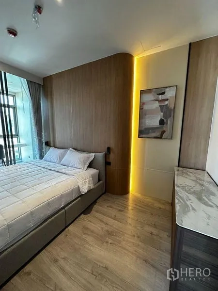 公寓 出租在Watthana, Bangkok - 温馨卧室，木质墙面与氛围灯，双人床及靠窗大理石台面。