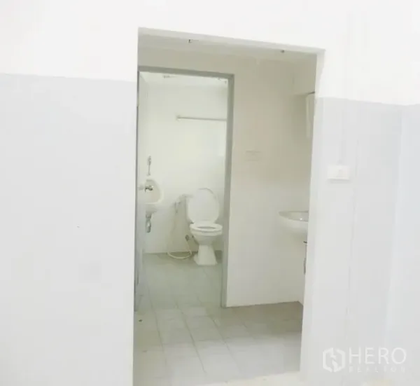 Factory for sale in Pathum Thani - Clean staff restroom with toilet, urinal and washbasin inside the factory.