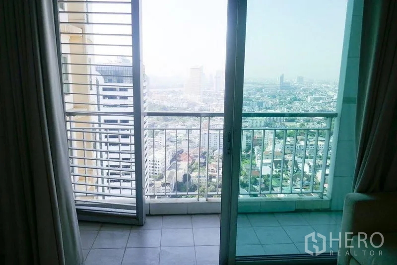 Condominium for rent or sale in Khlong San, Bangkok - Sliding glass door to a balcony with railings and panoramic Bangkok city skyline view.