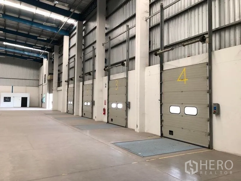 Warehouse for rent in Bang Phli, Samut Prakan - Interior row of numbered loading doors with dock levelers for efficient loading.