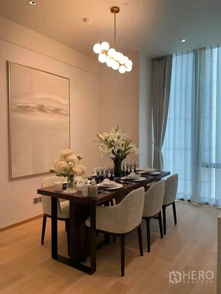 Condominium for rent in Pathum Wan, Bangkok - Elegant dining area for six with a pendant light and large wall art.