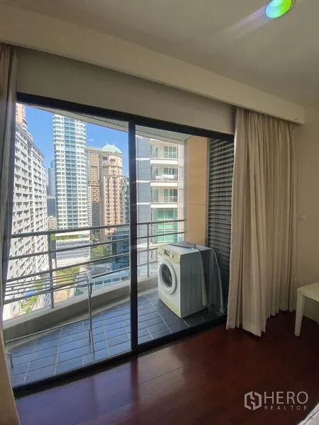 公寓 出租在Pathum Wan, Bangkok - 推拉门通往阳台，设洗衣机与城市景观。