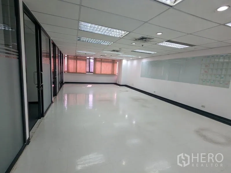 办公空间 出租或出售在Ratchathewi, Bangkok - 明亮的开放式办公室，吊顶灯、白色地砖、玻璃隔间与带百叶的大窗，临近BTS帕亚泰站。