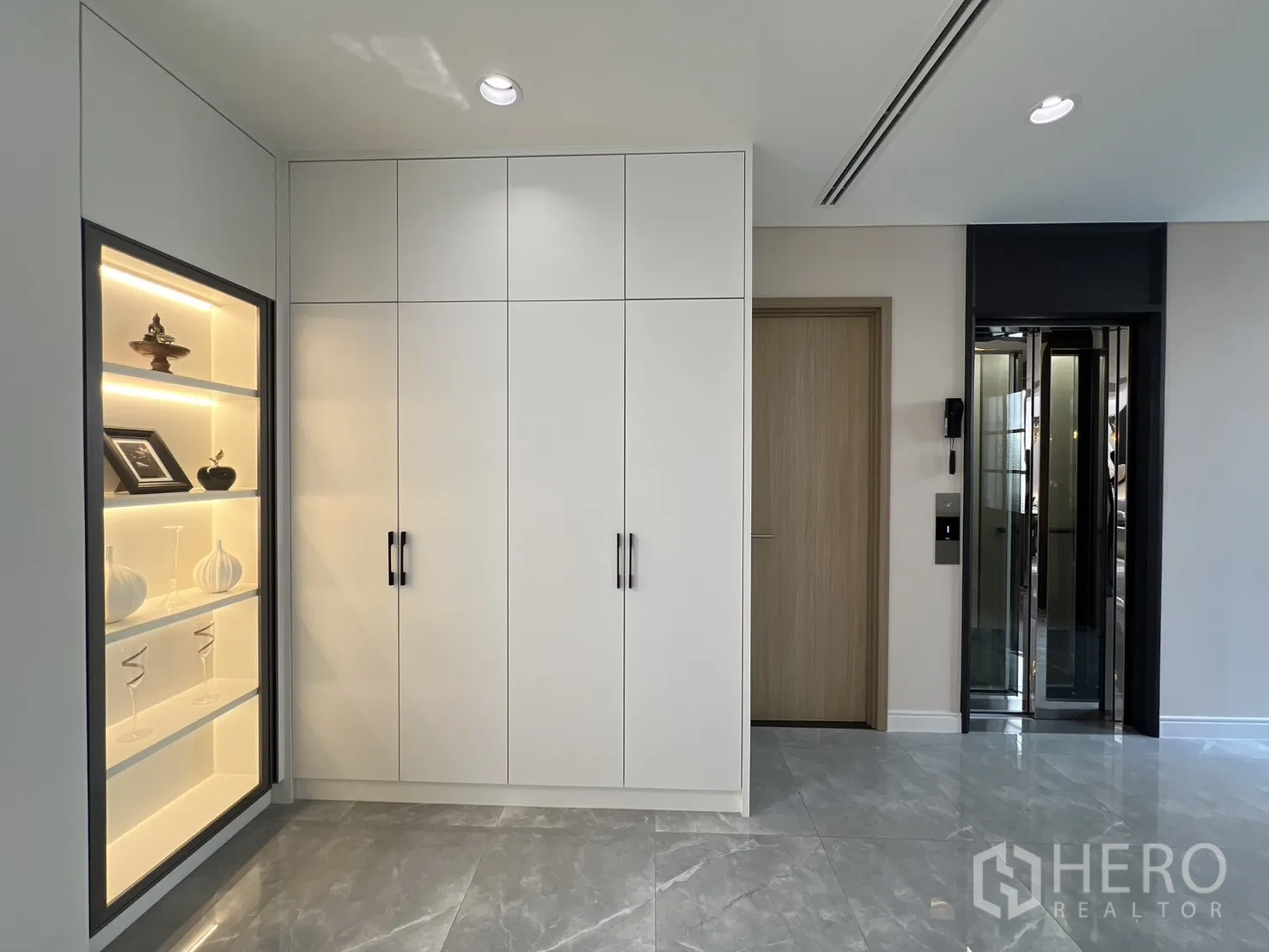 Semi-detached House for sale in Yan Nawa, Bangkok - Hallway with illuminated display shelves, storage cabinets, and a private home elevator.