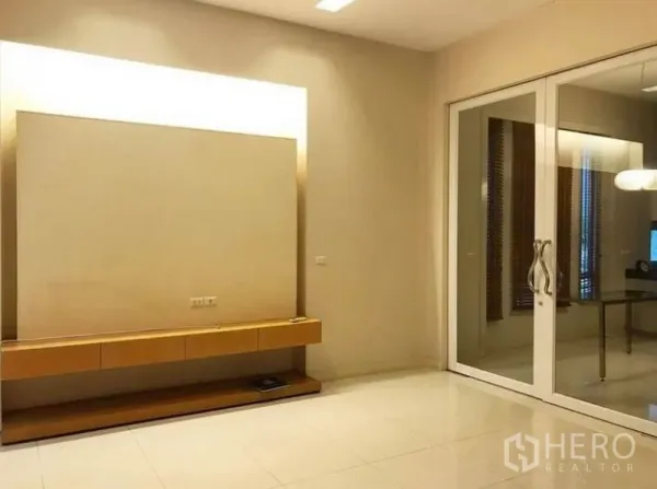 Townhouse for rent in Wang Thonglang, Bangkok - Spacious media room with built-in TV console and sliding glass doors.
