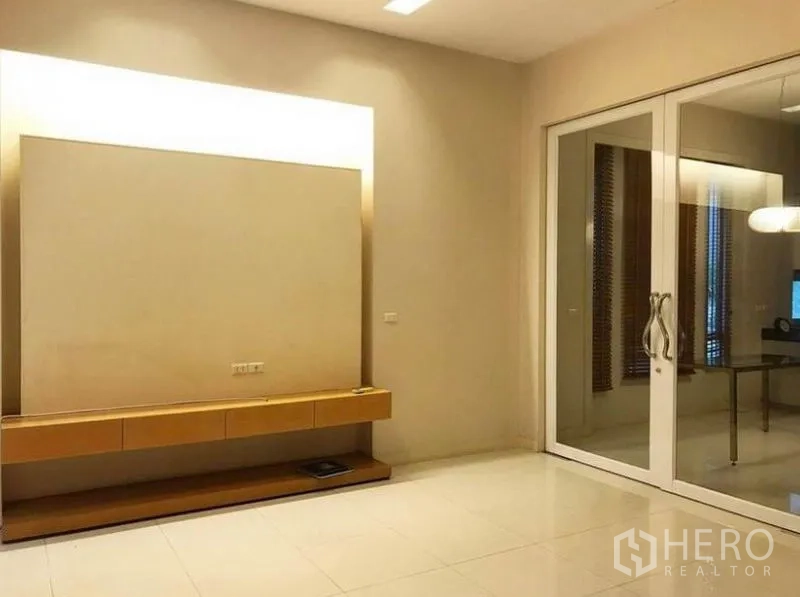 Townhouse for rent in Wang Thonglang, Bangkok - Spacious media room with built-in TV console and sliding glass doors.