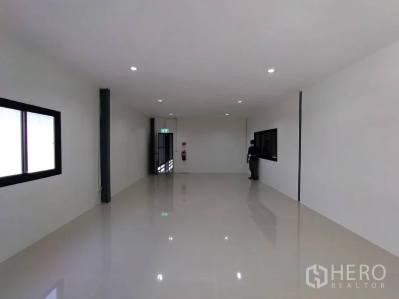 คลังสินค้า ให้เช่าในBang Phli, Samut Prakan - ห้องออฟฟิศมีหน้าต่าง ดาวน์ไลท์ และประตูทางออกฉุกเฉินภายในโกดัง.