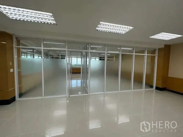 Office Space for rent in Suan Luang, Bangkok - Open-plan workspace facing a full wall of frosted glass partitions under grid ceiling lights.