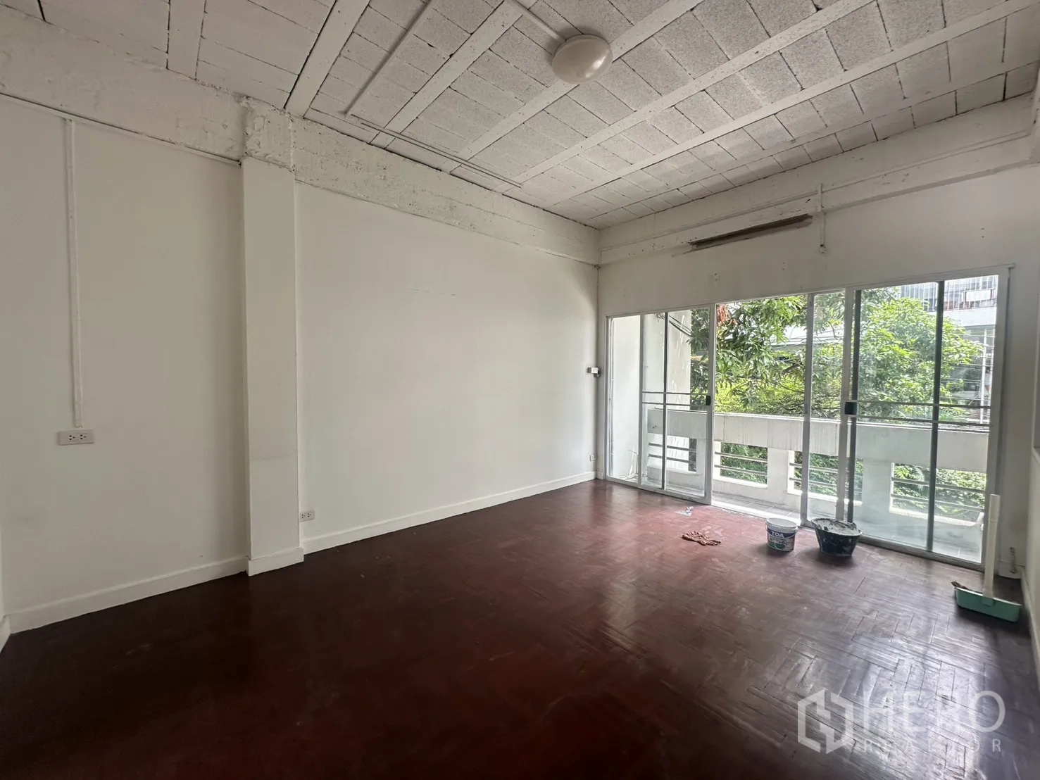 โฮมออฟฟิศ for rent in Watthana, Bangkok - ห้องชั้นบนมีประตูกระจกบานเลื่อนออกสู่ระเบียงเห็นต้นไม้.