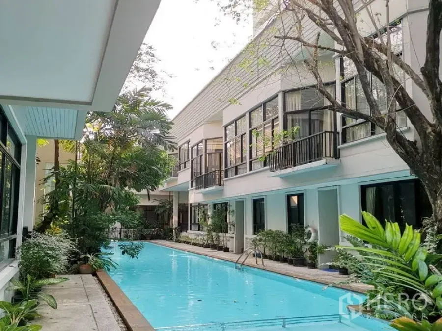 Detached House for rent in Khlong Toei, Bangkok - Long lap pool bordered by modern white houses and tropical plants
