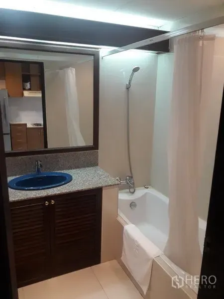 公寓 出租在Watthana, Bangkok - 浴室配浴缸、花洒和石质台面洗手台，蓝色水槽。