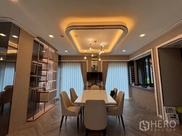 Detached House for rent in Lat Krabang, Bangkok - Elegant dining room with a marble-top table, built-in shelving and warm ceiling lighting.