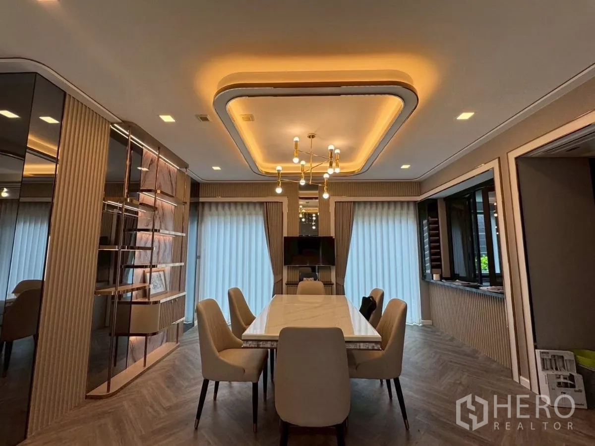 Detached House for rent in Lat Krabang, Bangkok - Elegant dining room with a marble-top table, built-in shelving and warm ceiling lighting.