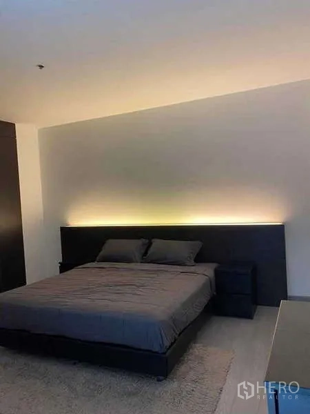 公寓 出租或出售在Watthana, Bangkok - 温馨卧室，深色床架与背光床头。