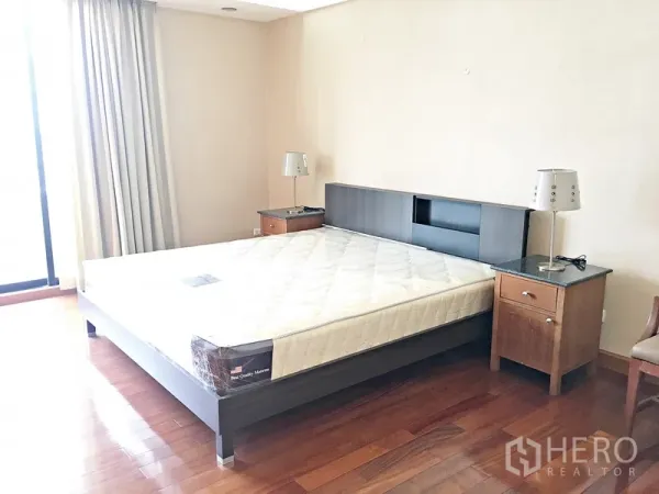 公寓 出租在Pathum Wan, Bangkok - 阳光卧室，配大床、床头柜与木地板。