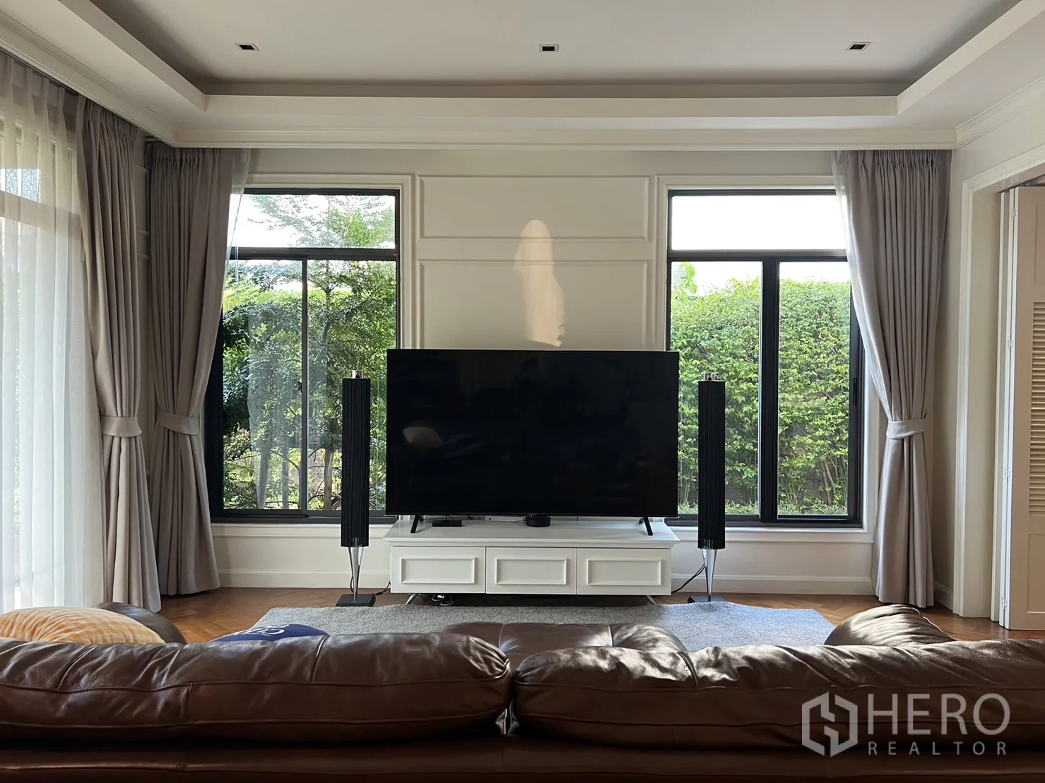 บ้าน ให้เช่าในSuan Luang, Bangkok - ห้องนั่งเล่นสว่างด้วยหน้าต่างบานใหญ่ ผ้าม่าน และตู้วางทีวี