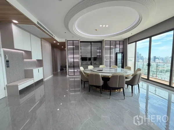 Condominium for sale in Watthana, Bangkok - Dining room with circular table, ceiling feature, and balcony-style glazing.