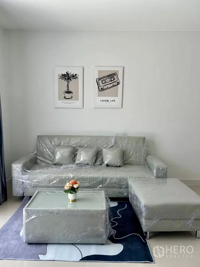 Townhouse for rent in Bang Phli, Samut Prakan - Bright living room with new gray sofa set, coffee table and wall art.