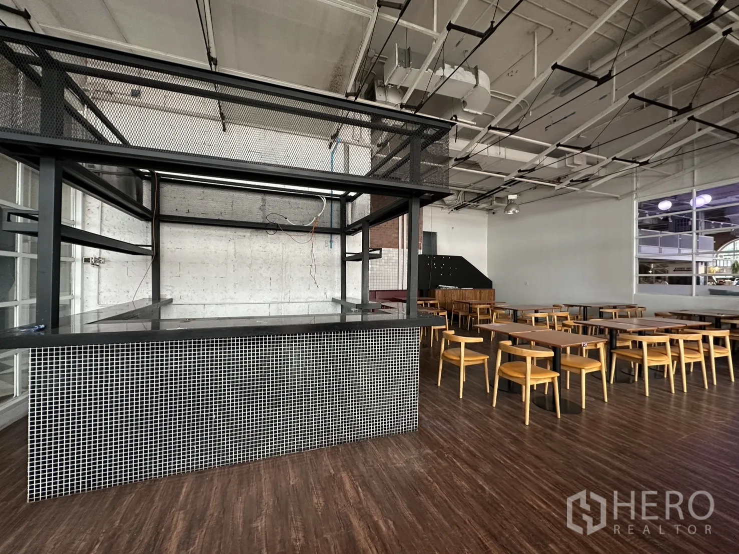 Retail Space for rent in Watthana, Bangkok - Central service counter with black metal frame and mosaic tile base under an exposed ceiling.