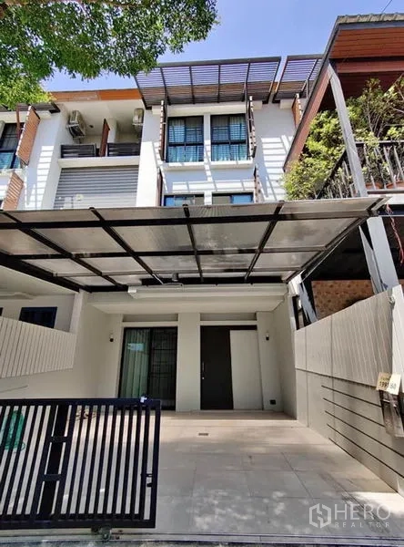 Townhouse for rent in Suan Luang, Bangkok - Modern three-storey townhouse facade with covered carport and gate in Suan Luang, Bangkok