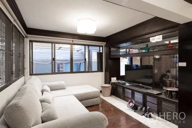 Detached House for rent in Watthana, Bangkok - Living room with L-shaped sofa, built-in media cabinet and wide windows.