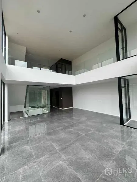 带办公室的家 出租或出售在Lat Phrao, Bangkok - 挑高双层客厅/办公区，落地玻璃与夹层走廊。