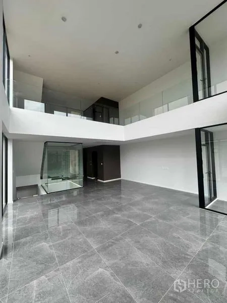 带办公室的家 出租或出售在Lat Phrao, Bangkok - 挑高双层客厅/办公区，落地玻璃与夹层走廊。