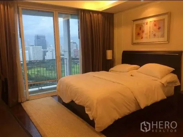 公寓 出售在Pathum Wan, Bangkok - 卧室带大床，连接阳台，可观城市与公园景观。