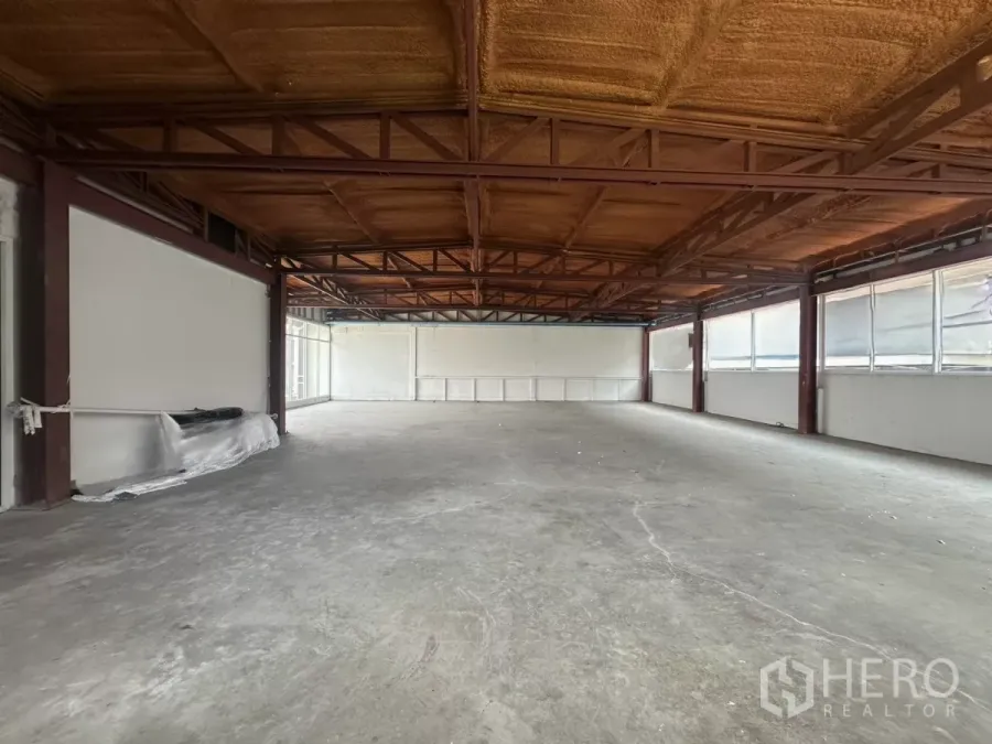 Retail Space for rent in Watthana, Bangkok - Open-plan 185 sqm retail floor in Watthana, Bangkok with exposed steel trusses, insulated ceiling, concrete floor and wraparound windows.