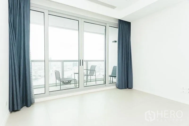 公寓 出售在Khlong San, Bangkok - 卧室另一角度，透过落地门可见阳台上的休闲座椅。