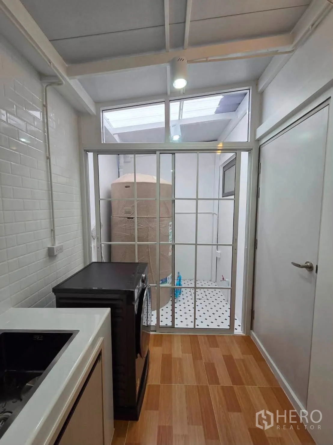 ทาวน์เฮาส์ for rent in Bang Phli, Samut Prakan - มุมซักล้างพร้อมเครื่องซักผ้าและประตูกระจกบานเลื่อนสู่ลานอเนกประสงค์.