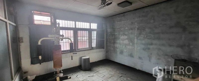 Shophouse for rent in Khlong Toei, Bangkok - Room with gym equipment and barred windows, flexible for studio use.