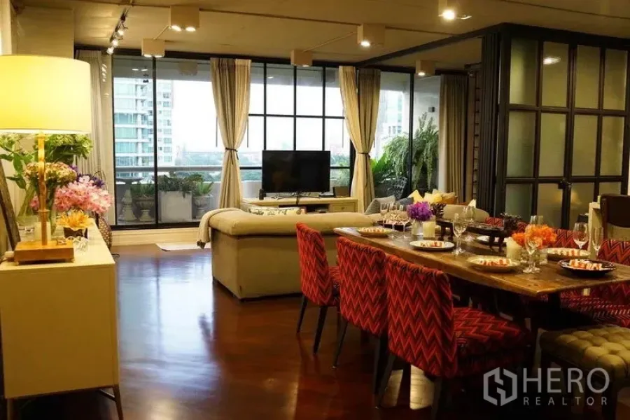 คอนโด ขายในPathum Wan, Bangkok - โต๊ะทานอาหารจัดครบและห้องนั่งเล่น เปิดออกสู่ระเบียงหน้าต่างสูง