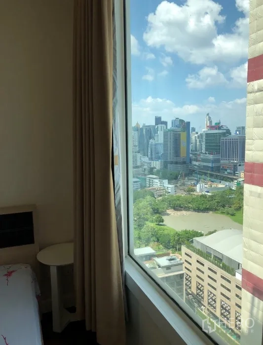 Condominium for rent or sale in Khlong Toei, Bangkok - Bedroom corner window showcasing panoramic city and park views.