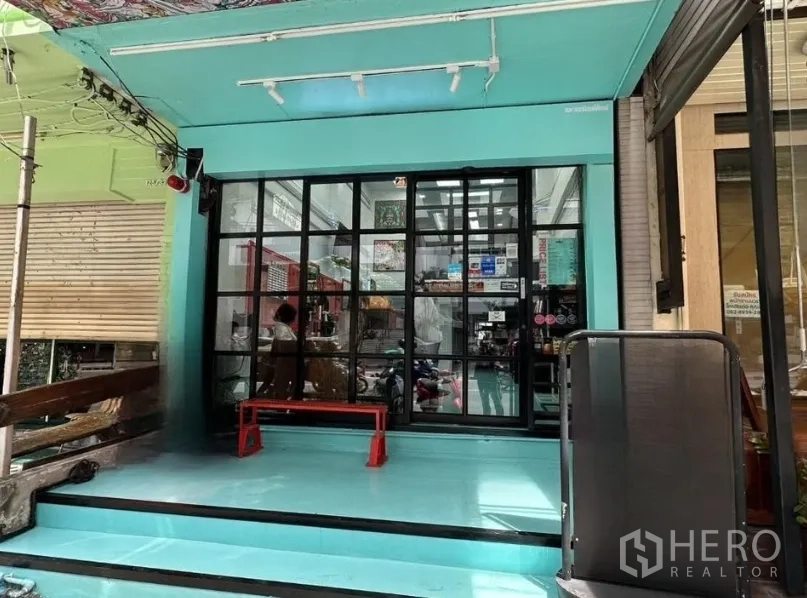 อาคารพาณิชย์ for sale in Watthana, Bangkok - ด้านหน้าอาคารพาณิชย์สีเทอร์ควอยซ์ ประตูกระจกกรอบดำ ทางเข้ายกระดับบนสุขุมวิท