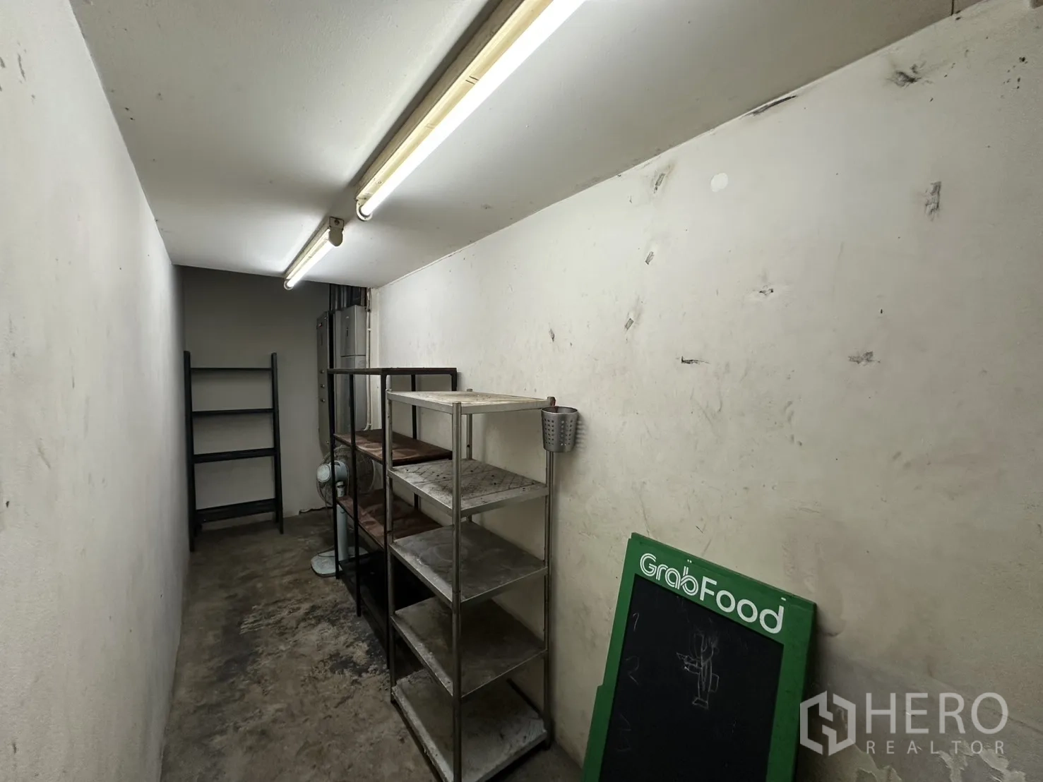 Retail Space for rent in Watthana, Bangkok - Narrow storage room with fluorescent lighting and metal shelving.
