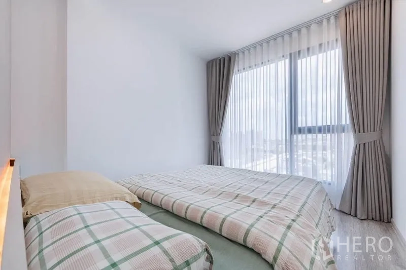 公寓 出租在Bang Na, Bangkok - 主卧配大转角窗与纱帘，自然采光充足。