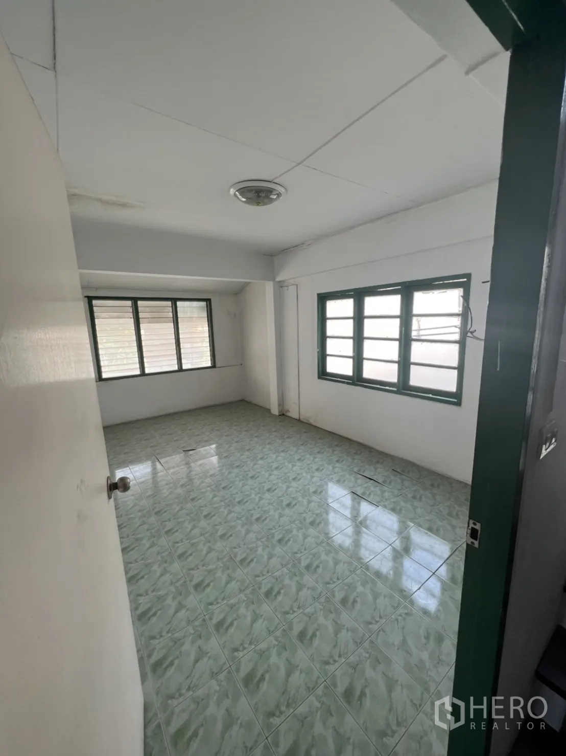 ทาวน์เฮาส์ ขายในWatthana, Bangkok - ห้องชั้นบนปูกระเบื้องเซรามิกสีเขียว มีหน้าต่างหลายบานรับแสงธรรมชาติ